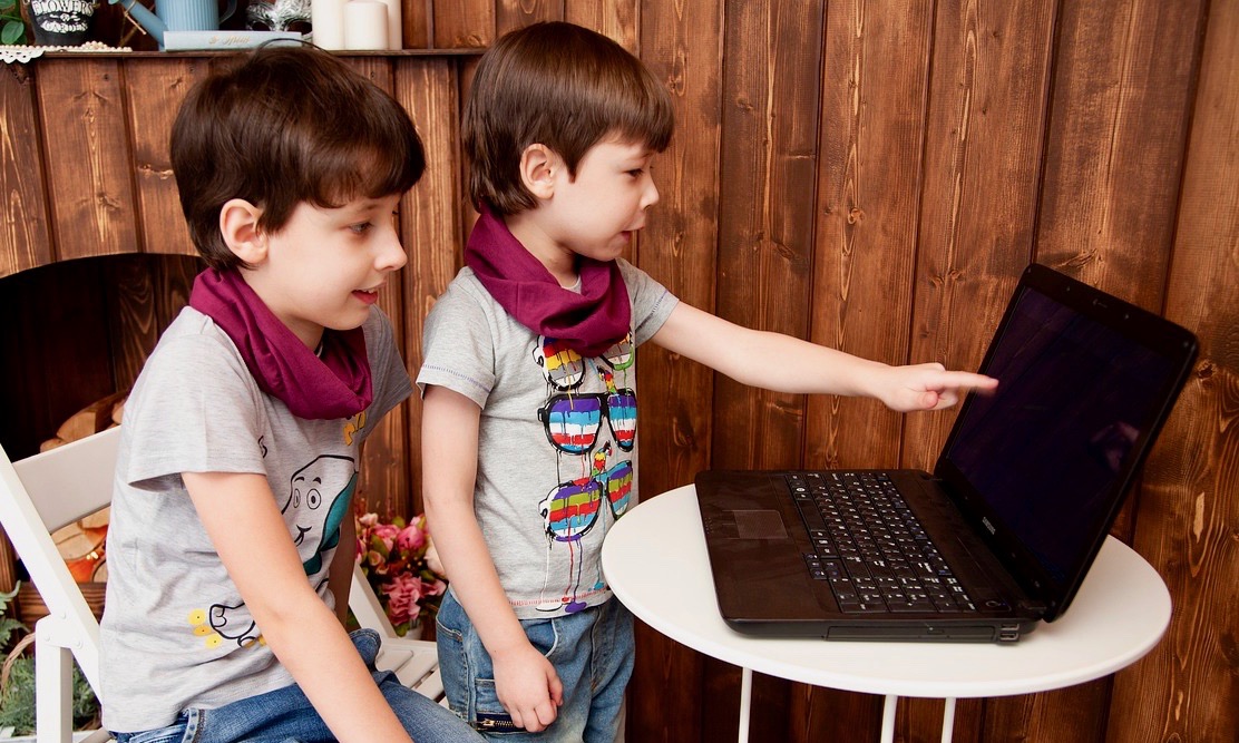 Zwei Kinder schauen auf einen Computer. | Foto: Victoria_Borodinova via pixabay.com
