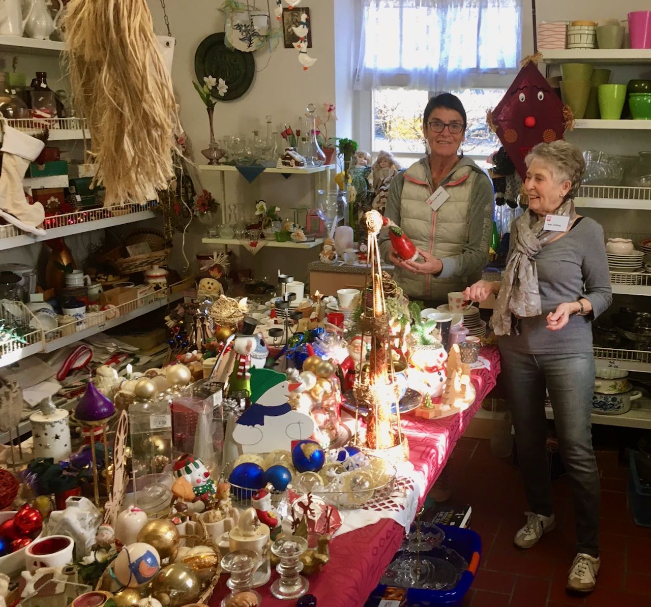 Traute Malorny und Gabi Stölting (v.l.) sortieren das Advents- und Weihnachtsangebot im FAIRKAUF-Laden. | Foto: Jacobi / Caritas Südniedersachsen