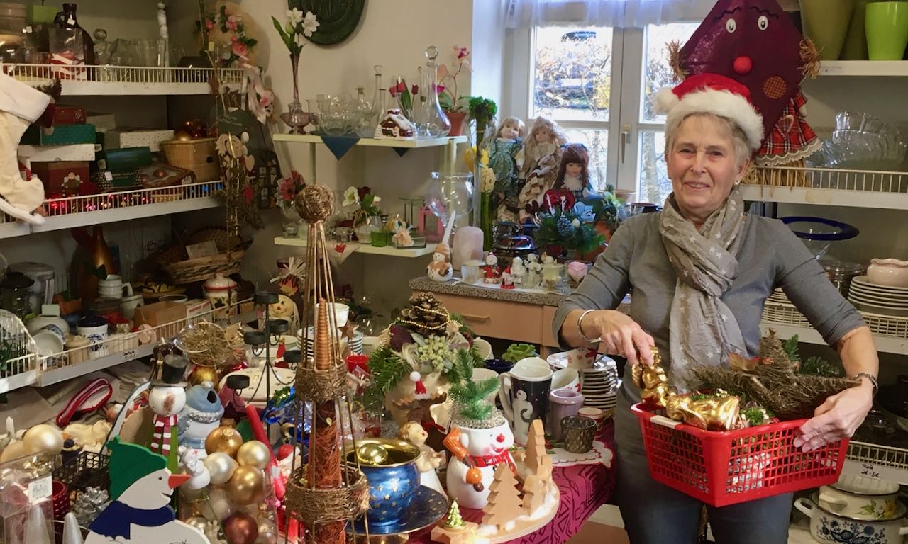 FAIRKAUF-Laden-Mitarbeiterin Gabi Stölting befüllt beispielhaft einen Einkaufskorb mit Advents- und Weihnachtsartikeln. | Foto: Jacobi / Caritas Südniedersachsen